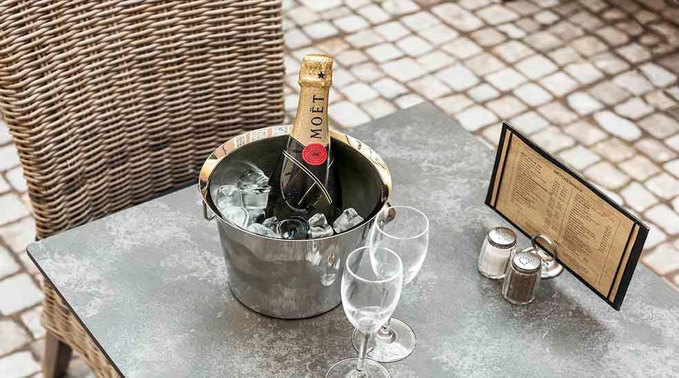 Restaurant med bord og stoler med champagne og menu ved Clarion Collection Hotel Victoria Jönköping 